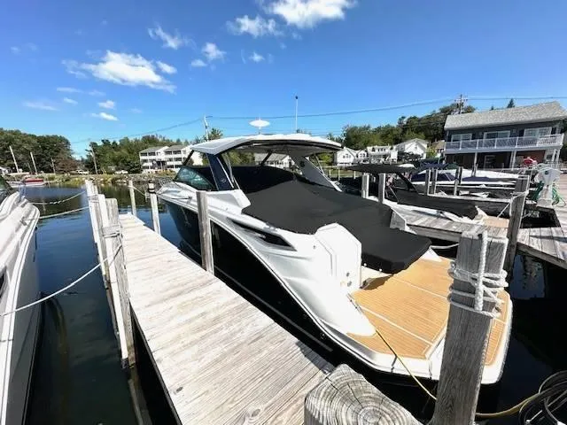 Slide: The Image of 2024 Sea Ray 320DA boat docked at marina under clear blue sky. - 18