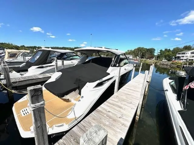 Slide: The Image of 2024 Sea Ray 320DA boat docked at marina under clear blue sky. - 19