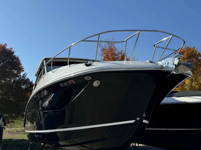 Slide: The Image of 2024 Sea Ray 320DA boat with sleek black hull, docked outdoors. - 2