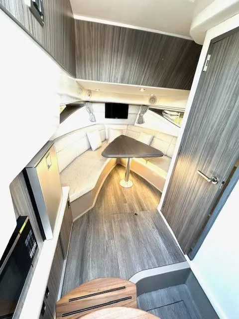 Slide: The Image of 2024 Sea Ray 320DA cabin interior with modern seating and table. - 20