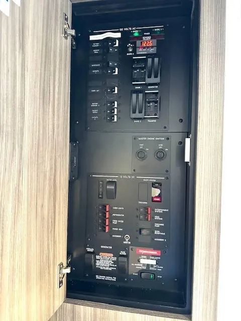 Slide: The Image of Electrical panel inside 2024 Sea Ray 320DA boat, featuring switches and controls. - 22