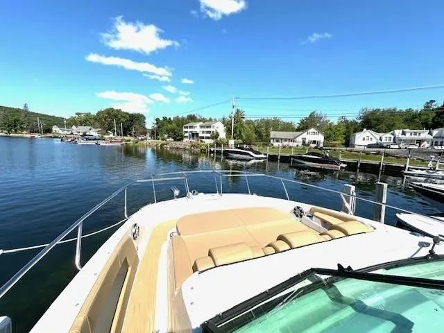 Slide: The Image of 2024 Sea Ray 320DA yacht docked in scenic marina under clear blue sky. - 26