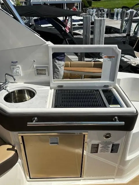 Slide: The Image of 2024 Sea Ray 320DA yacht kitchenette with sink and grill. - 28