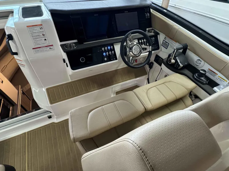 Slide: The Image of 2024 Sea Ray 320DA helm with modern controls and beige seating. - 5