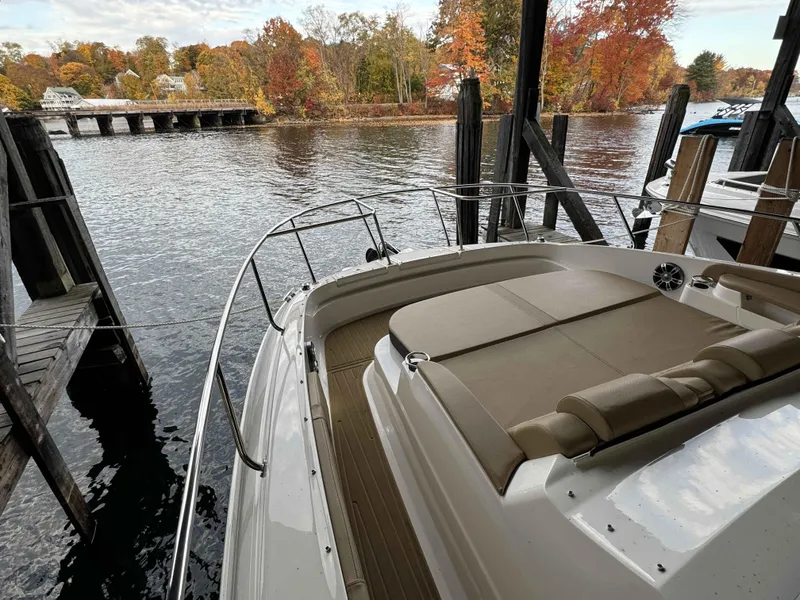 Slide: The Image of 2024 Sea Ray 320DA boat docked by autumn foliage and calm water. - 7