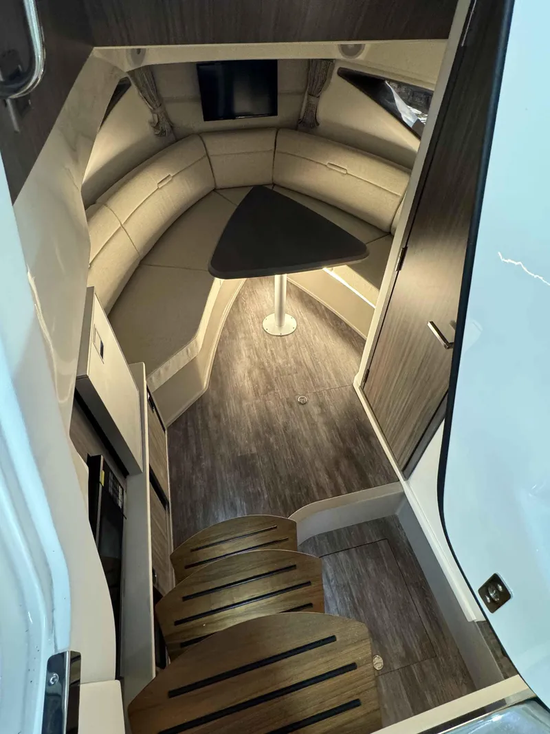 Slide: The Image of 2024 Sea Ray 320DA cabin interior with modern seating and table. - 8