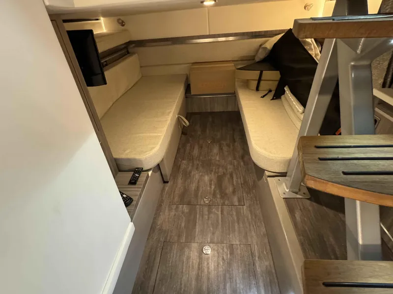 Slide: The Image of 2024 Sea Ray 320DA cabin interior with beige seating and wooden flooring. - 9