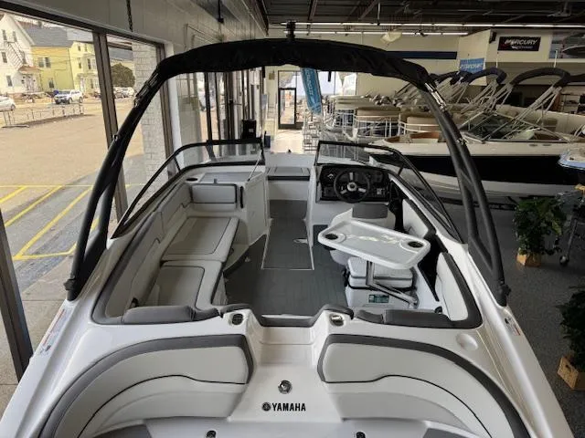 Slide: The Image of 2025 Yamaha Boats AR190 interior with seating and steering wheel in showroom. - 14