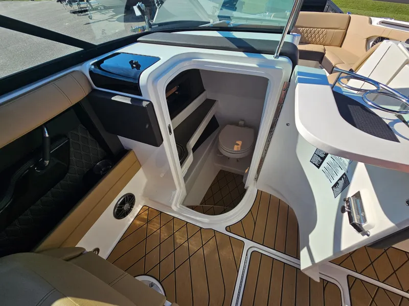 Slide: The Image of 2022 Sea Ray SLX 250 interior with wood flooring and compact cabin space. - 13