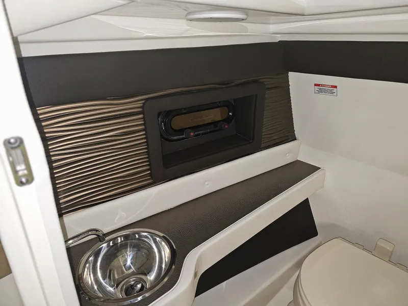 Slide: The Image of 2022 Sea Ray SLX 250 interior bathroom with sink and toilet, modern design. - 14