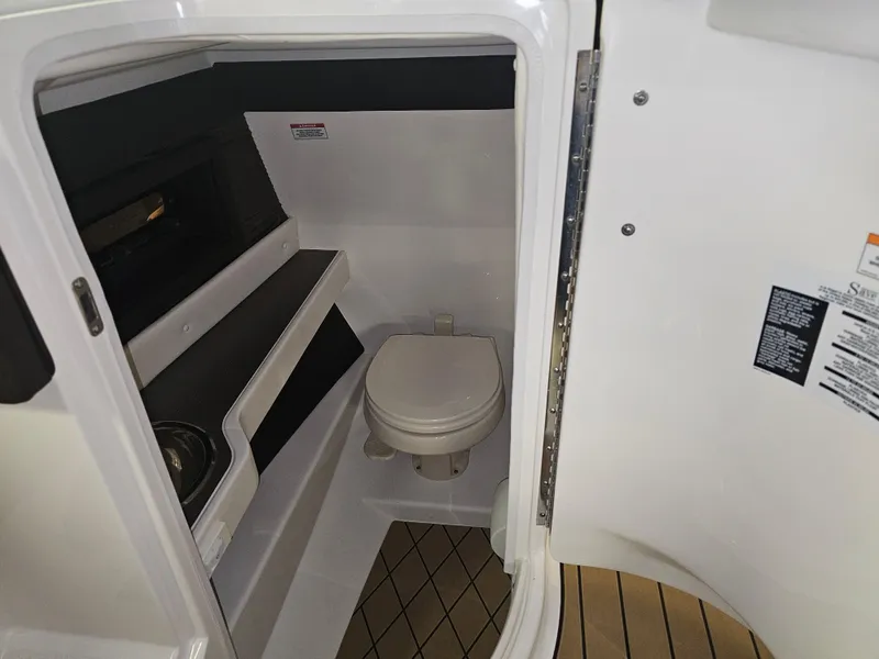 Slide: The Image of 2022 Sea Ray SLX 250 boat interior with compact bathroom and toilet. - 15