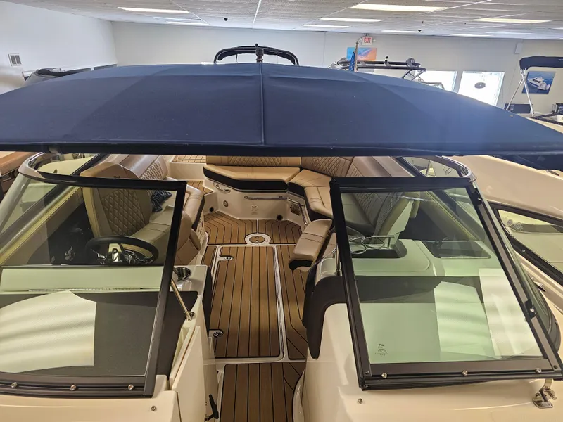 Slide: The Image of 2022 Sea Ray SLX 250 boat interior with seating and canopy, displayed indoors. - 19