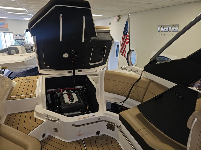 Slide: The Image of 2022 Sea Ray SLX 250 boat interior with open engine compartment in showroom. - 23