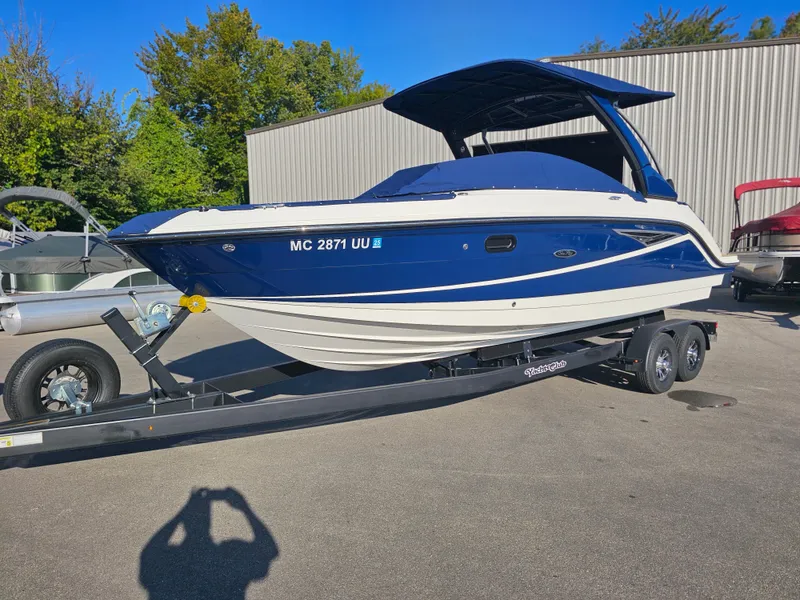Slide: The Image of 2022 Sea Ray SLX 250 boat on trailer, blue and white design, parked outdoors. - 29