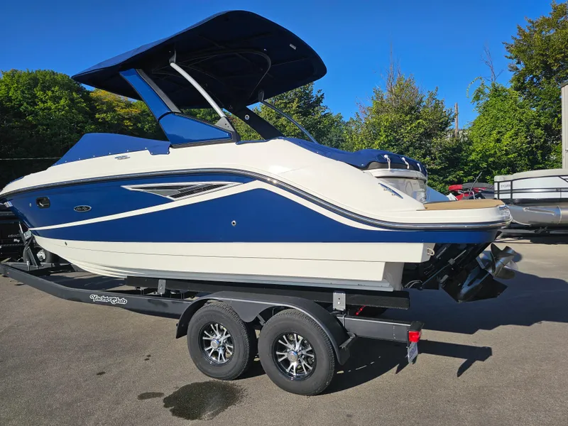 Slide: The Image of 2022 Sea Ray SLX 250 boat on trailer, blue and white design, parked outdoors. - 30