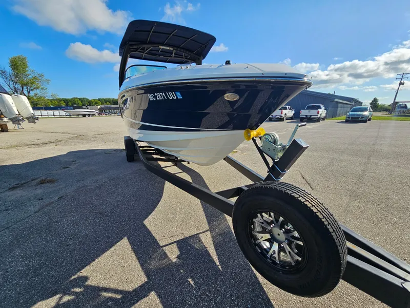 Slide: The Image of 2022 Sea Ray SLX 250 boat on trailer under clear blue sky. - 31
