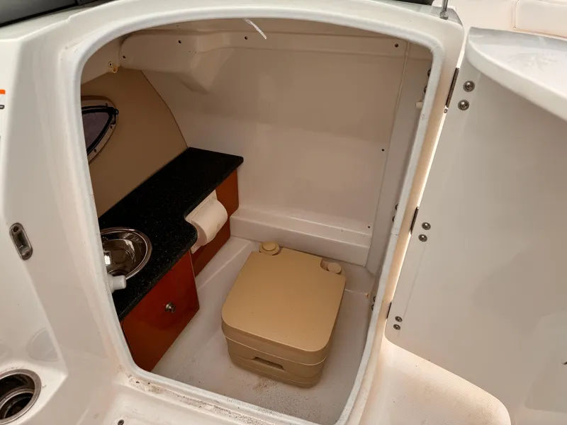 Slide: The Image of 2012 Chaparral 244 Sunesta boat interior with compact bathroom and sink. - 10