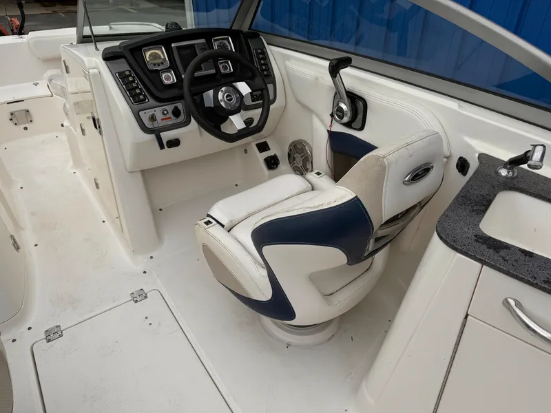 Slide: The Image of 2012 Chaparral 244 Sunesta boat interior with steering wheel and captain's chair. - 12