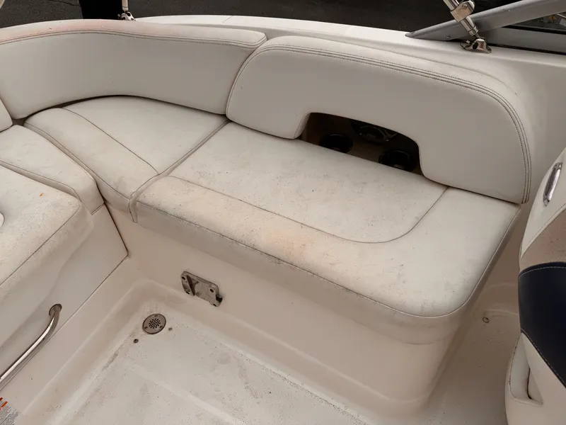 Slide: The Image of 2012 Chaparral 244 Sunesta boat interior with white seating and storage compartment. - 13