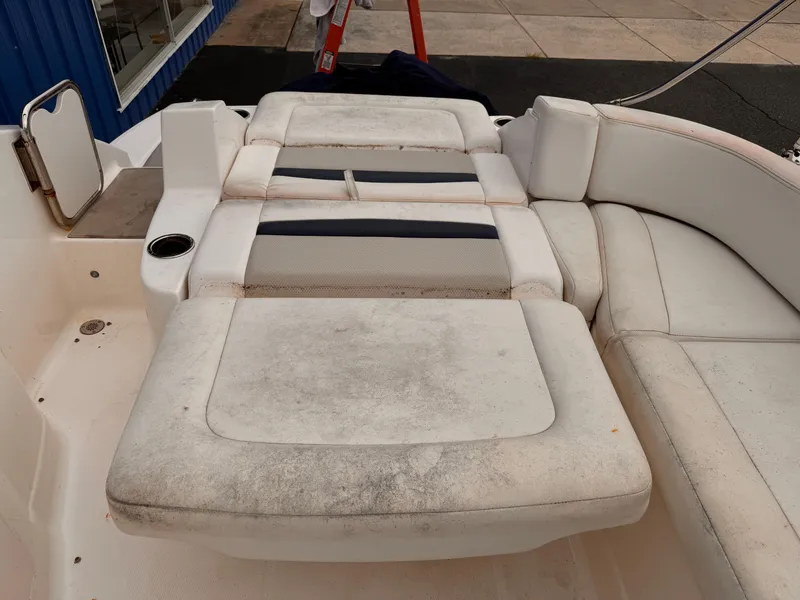 Slide: The Image of 2012 Chaparral 244 Sunesta boat interior with worn, white seating and cup holder. - 15