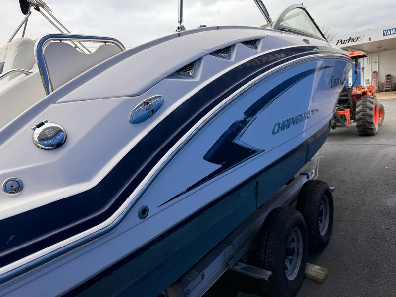 Slide: The Image of 2012 Chaparral 244 Sunesta boat on trailer, side view, in a marina setting. - 3