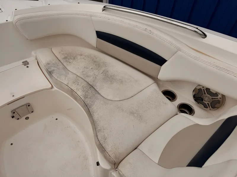 Slide: The Image of 2012 Chaparral 244 Sunesta boat interior with worn seating and cup holders. - 7