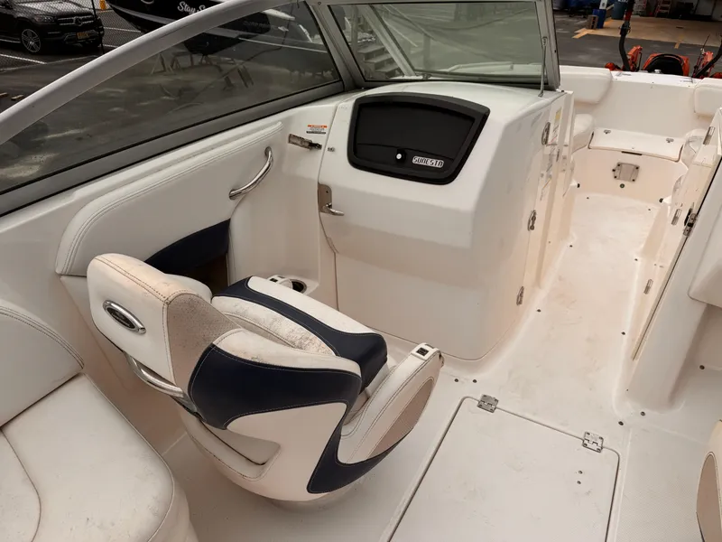 Slide: The Image of 2012 Chaparral 244 Sunesta boat interior with helm and seating area. - 9
