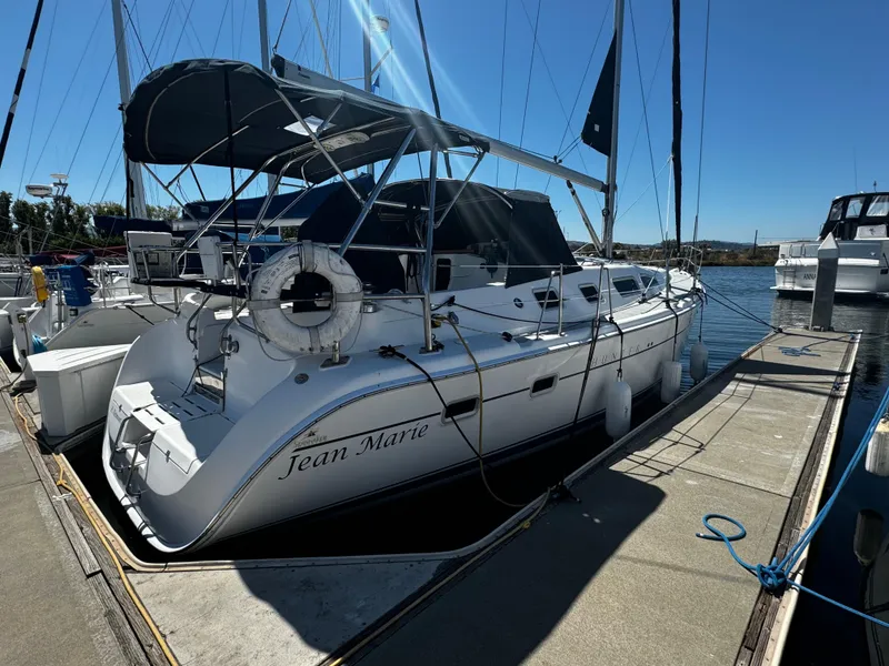 Slide: The Image of 2007 Hunter 41 sailboat docked, featuring a canopy and lifebuoy, named "Jean Marie." - 10