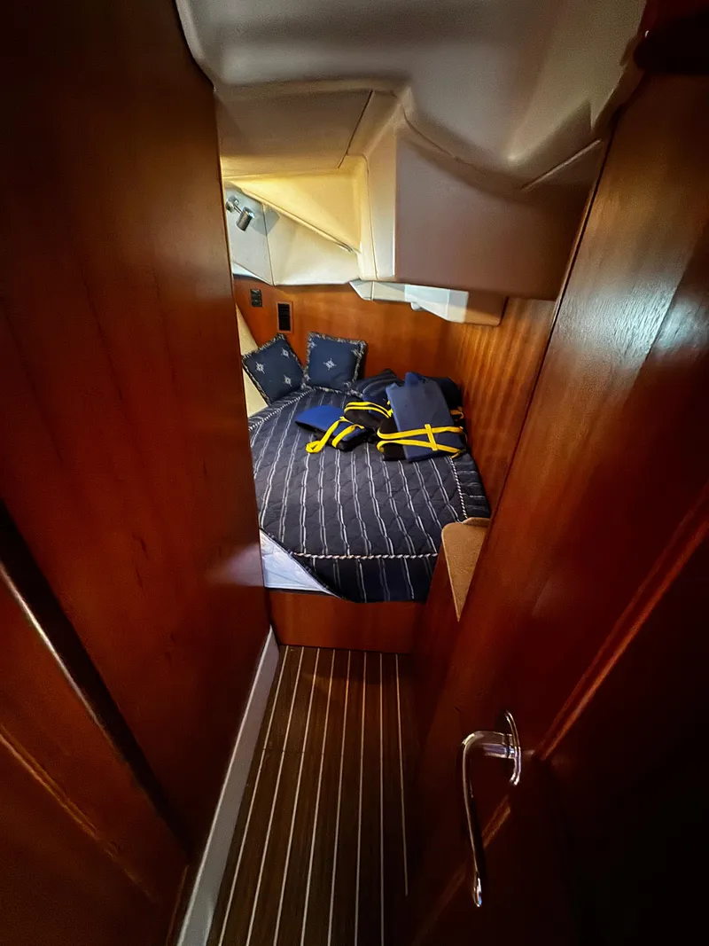 Slide: The Image of Cozy cabin interior of 2007 Hunter 41 sailboat with striped bedding and wooden finish. - 13