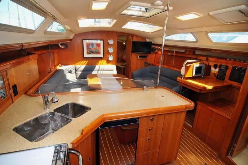 Slide: The Image of Interior of 2007 Hunter 41 sailboat with modern kitchen and cozy seating area. - 16