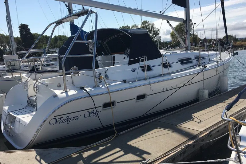 Slide: The Image of 2007 Hunter 41 sailboat docked at marina, featuring sleek design and spacious deck. - 2