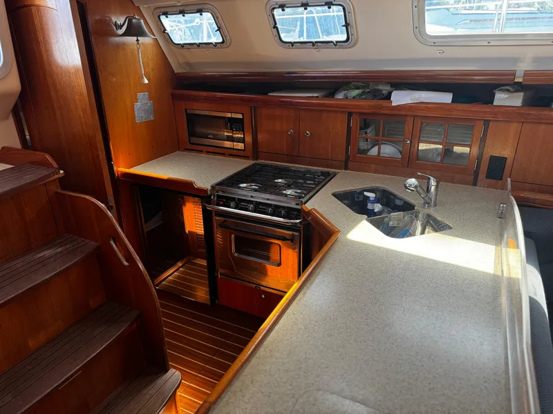 Slide: The Image of 2007 Hunter 41 yacht interior kitchen with wooden cabinetry and modern appliances. - 22