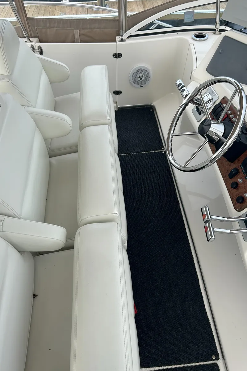 Slide: The Image of 2004 Silverton 39 Motor Yacht interior with white seating and steering wheel. - 17