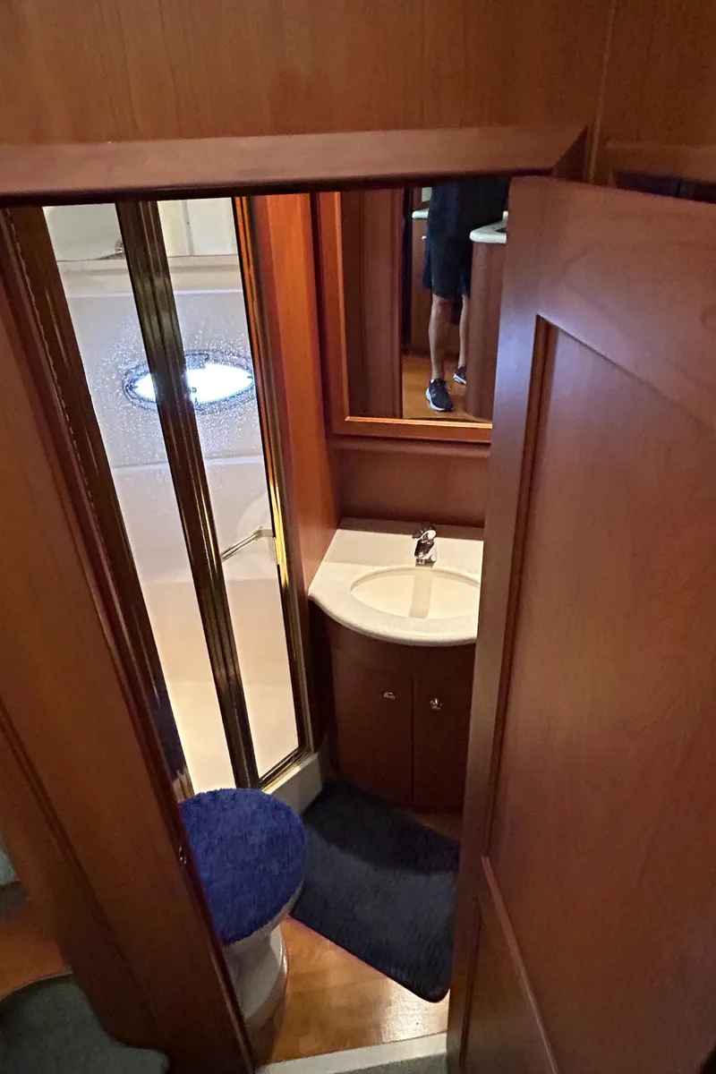 Slide: The Image of 2004 Silverton 39 Motor Yacht bathroom with shower, sink, and wooden cabinetry. - 29