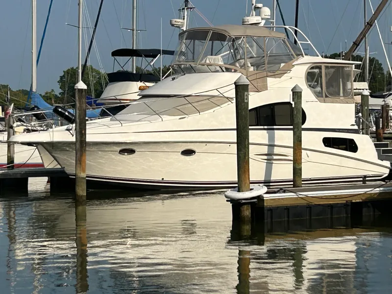 Slide: The Image of 2004 Silverton 39 Motor Yacht docked in a marina, reflecting on calm water. - 3