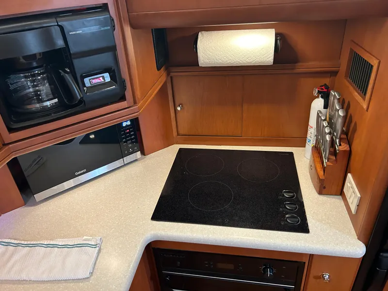Slide: The Image of 2004 Silverton 39 Motor Yacht kitchen with stove, microwave, and coffee maker. - 31