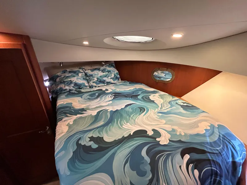 Slide: The Image of Luxurious 2004 Silverton 39 Motor Yacht bedroom with ocean-themed bedding. - 33