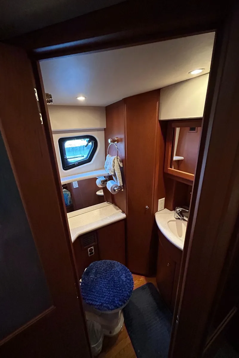 Slide: The Image of 2004 Silverton 39 Motor Yacht bathroom with wood accents and porthole window. - 34