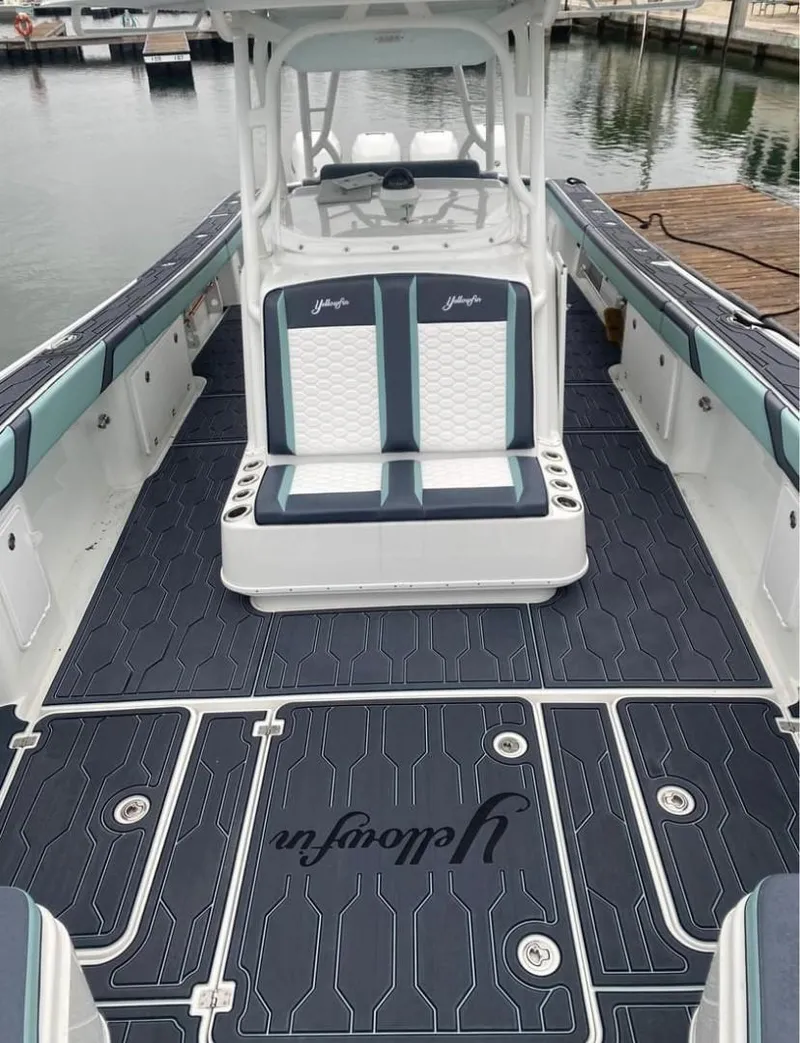 Slide: The Image of 2016 Yellowfin 39 boat interior with custom seating and flooring at a marina. - 8