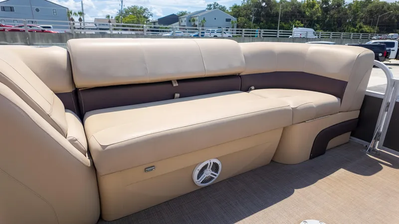 Slide: The Image of 2019 Sun Tracker 24 DLX Party Barge interior with beige seating and speaker. - 10