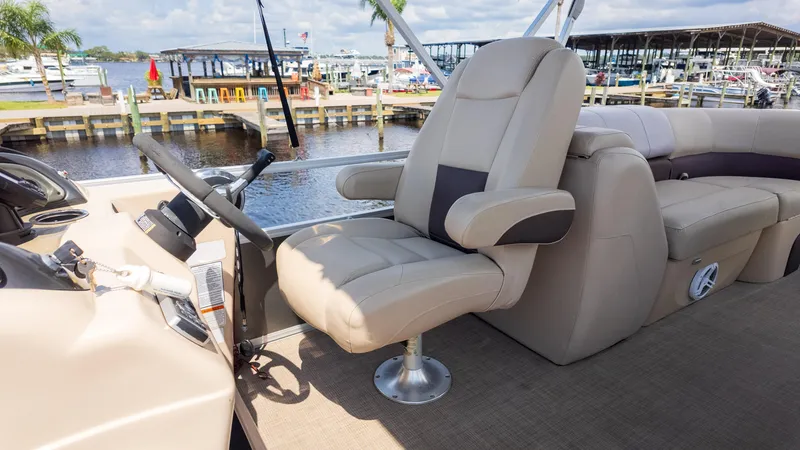 Slide: The Image of 2019 Sun Tracker 24 DLX Party Barge helm with comfortable seating and waterfront view. - 11