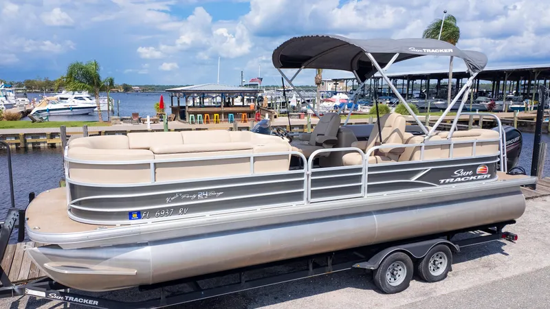 Slide: The Image of 2019 Sun Tracker 24 DLX Party Barge pontoon boat docked by a marina. - 12