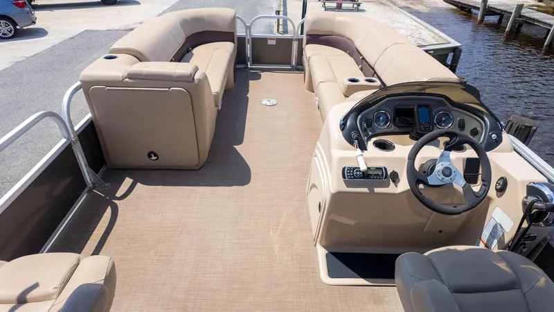 Slide: The Image of 2019 Sun Tracker 24 DLX Party Barge interior with beige seating and steering console. - 15