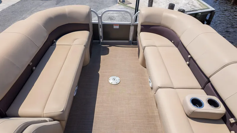 Slide: The Image of 2019 Sun Tracker 24 DLX Party Barge interior with beige seating and cup holders. - 16
