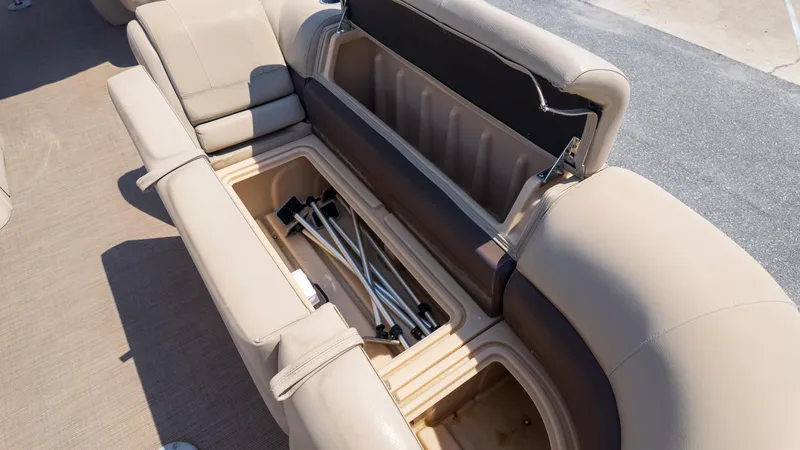 Slide: The Image of 2019 Sun Tracker 24 DLX Party Barge storage compartment with beige seating. - 22