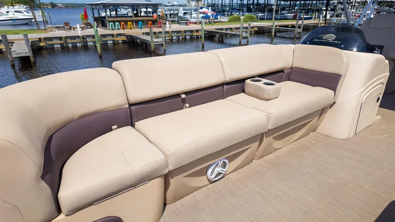 Slide: The Image of 2019 Sun Tracker 24 DLX Party Barge with beige seating, docked by a marina. - 23