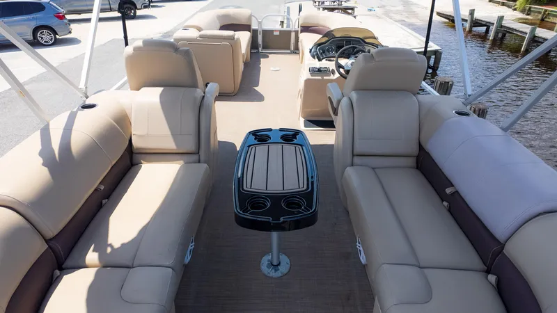 Slide: The Image of 2019 Sun Tracker 24 DLX Party Barge interior with beige seating and central table. - 5