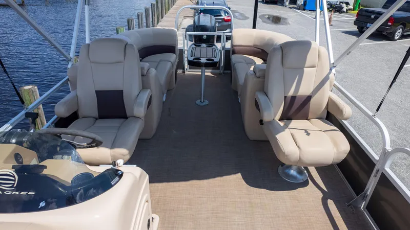 Slide: The Image of 2019 Sun Tracker 24 DLX Party Barge interior with plush seating and steering console. - 6