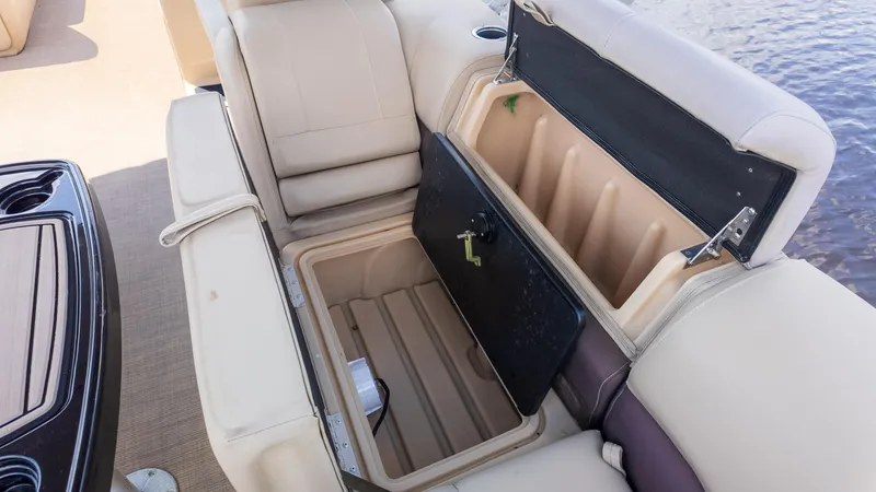 Slide: The Image of 2019 Sun Tracker 24 DLX Party Barge storage compartment with open seat lid. - 9