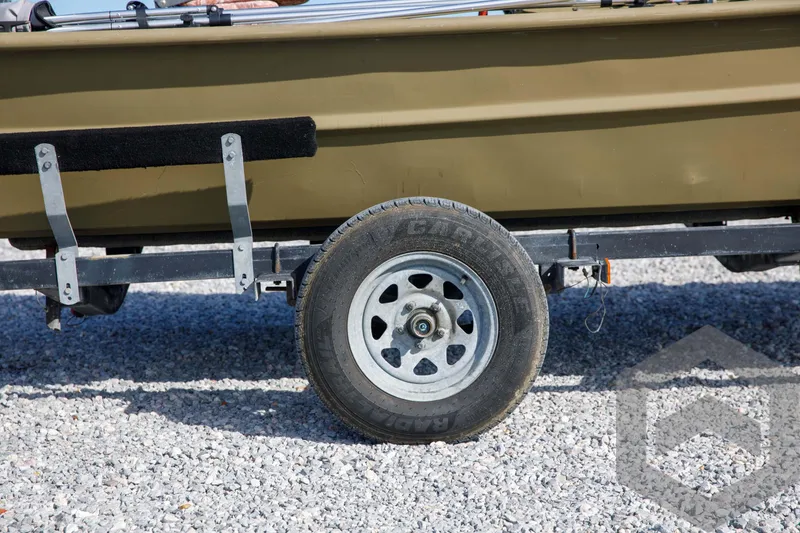 Slide: The Image of 2003 Polar Kraft Sportsman MV1885CC boat trailer wheel on gravel. - 10